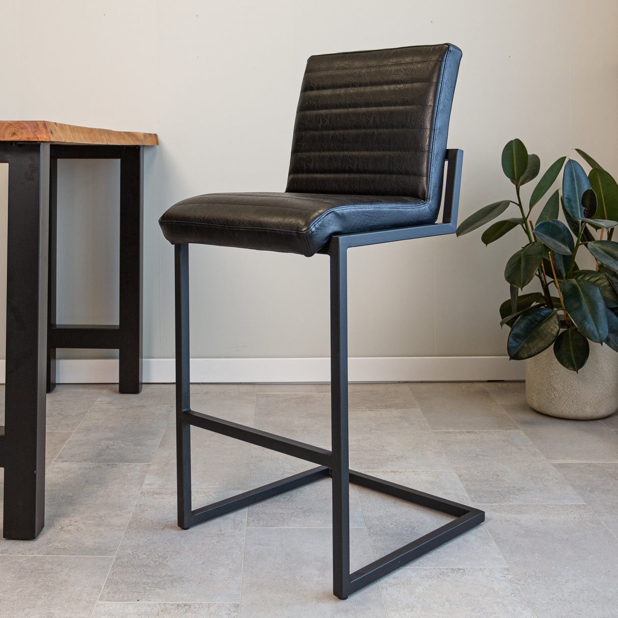 Barhocker Kuba Dimehouse Schwarz LxBxH 93x58x53 Kunstleder Stimmungsvolles Foto diagonal von vorne