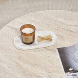 Runder Couchtisch mit Travertinplatte und dunklem Holzsockel in Kreuzform.