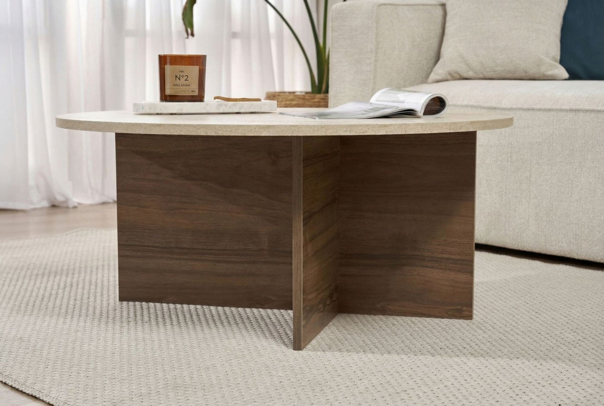 Runder Couchtisch mit Travertinplatte und dunklem Holzsockel in Kreuzform.