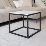 Beistelltisch Fien Dimehouse Weiß LxBxH 63x63x10 Gesinterter Stein Stimmungsvolles Foto diagonal von vorne